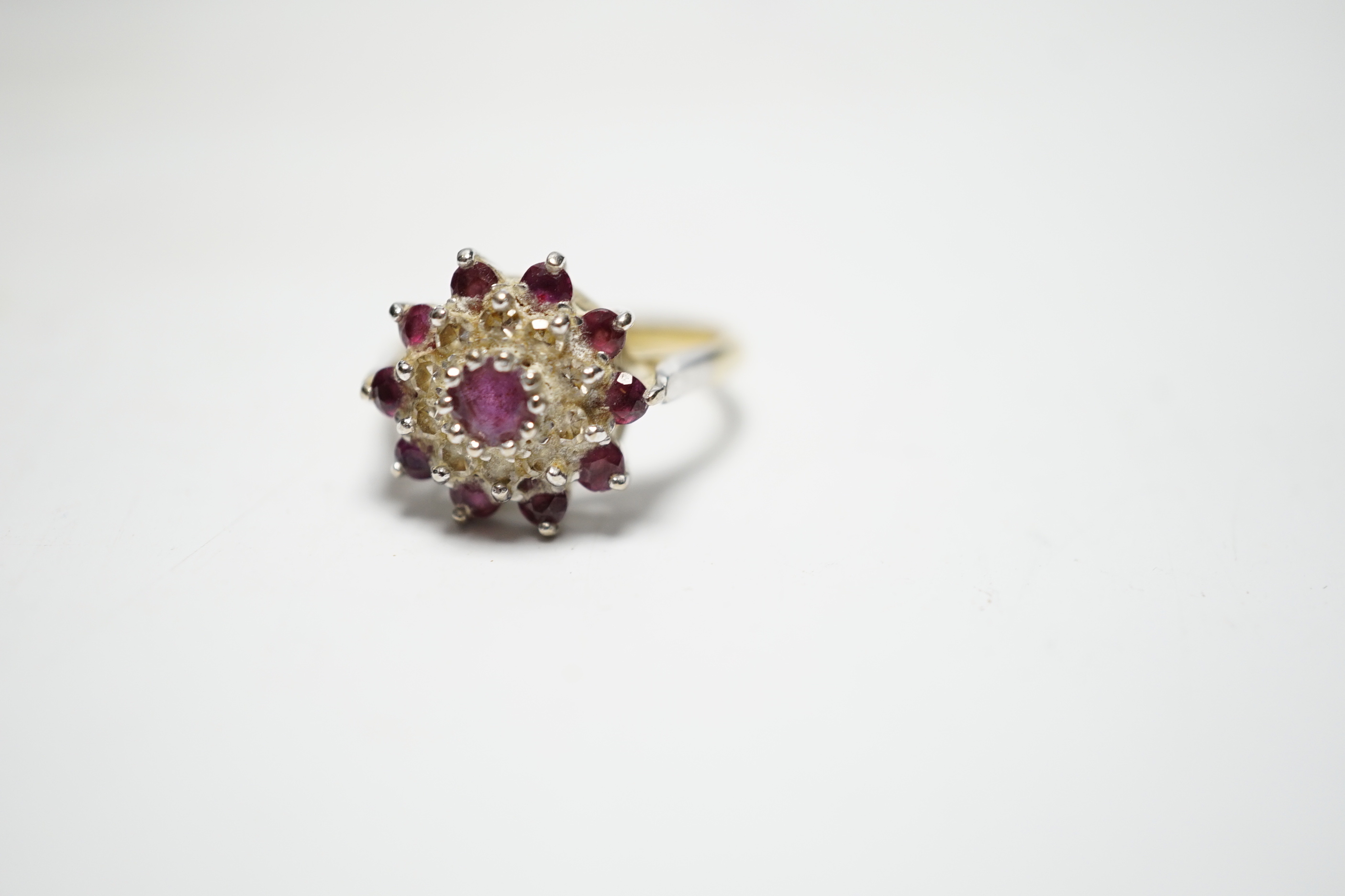 A modern 18ct gold, ruby and diamond set flowerhead cluster ring, size O, gross weight 5.2 grams.